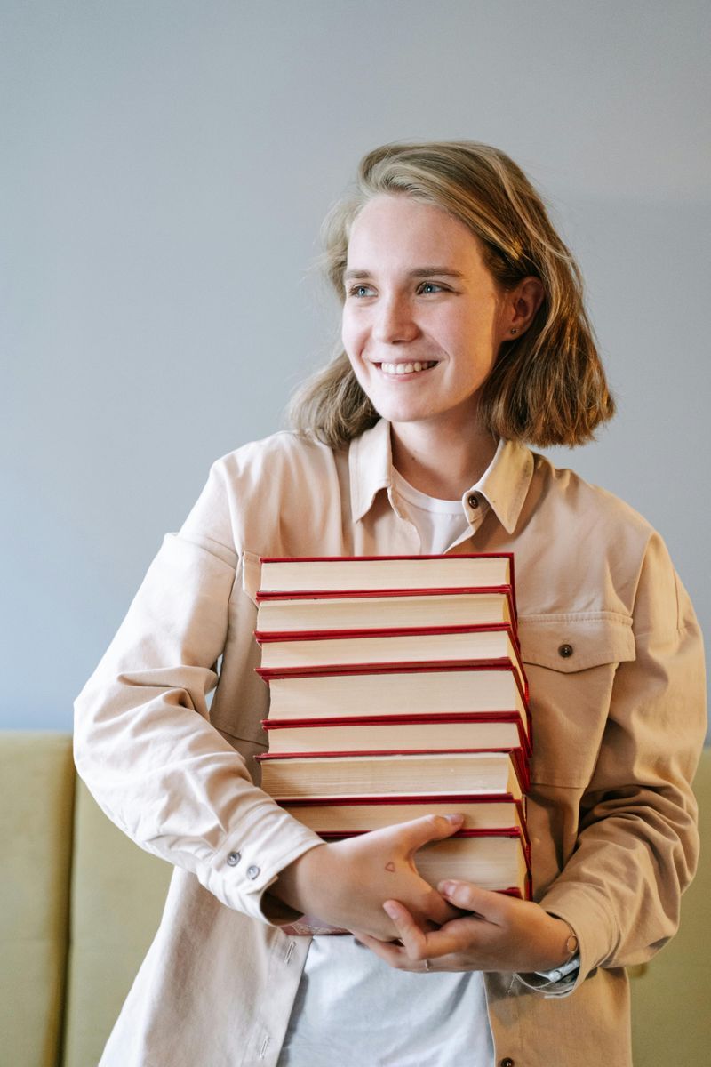 A student looking happy and holding textbooks